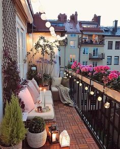 the balcony is decorated with potted plants and candles