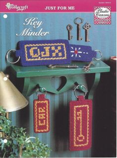 a crocheted key holder with keys hanging from it's hooks and two smaller key chains