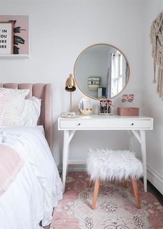 a white desk with a mirror and stool in a bedroom next to a pink rug