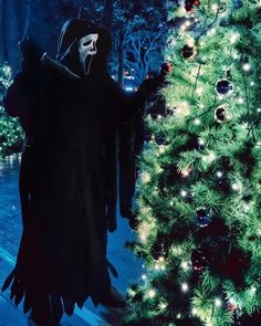 a person in a costume standing next to a christmas tree