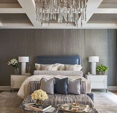 a large bed sitting in a bedroom next to a chandelier