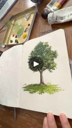 someone is drawing a tree with colored pencils and watercolors on the paper