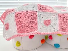 two crocheted baskets sitting on top of each other in front of a window