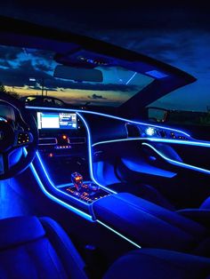 the interior of a car is lit up with blue lights