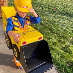 a little boy in a construction truck costume