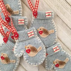 four blue mittens with red and white birds on them, hanging from a string