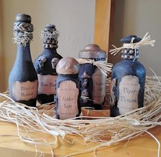 three bottles with labels on them sitting in a nest made out of branches and twigs