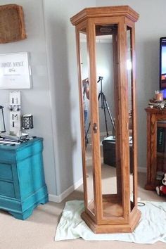 a wooden grandfather clock sitting in the middle of a living room next to a tv