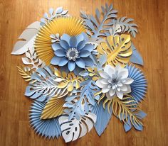 a bunch of paper flowers sitting on top of a wooden floor