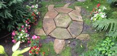 a stone path surrounded by plants and flowers