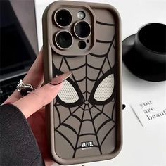 someone is holding up their phone case with the spiderman face on it