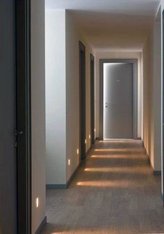 an empty hallway with light coming through the doors