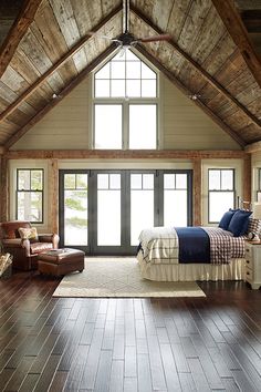 a bedroom with wood floors and vaulted ceiling