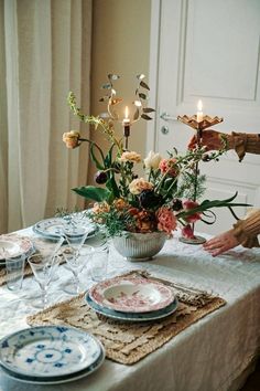 a table set with plates and flowers on it for a dinner party or special occasion