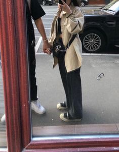 a woman standing in front of a mirror taking a selfie with her cell phone