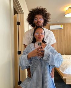 a man and woman taking a selfie in front of a mirror with their cell phone