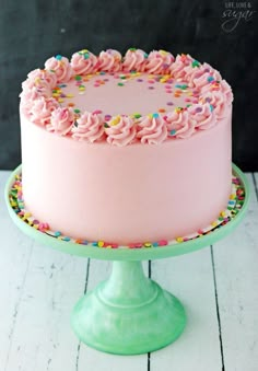 a pink frosted cake with sprinkles on top