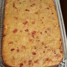 a casserole dish sitting on top of a metal pan covered in cheese and bacon