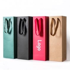 four different colored paper bags are lined up in a row with the word'100'on them