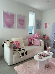 a living room filled with furniture and pink decor on the walls in front of windows