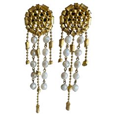 These vintage earrings make a powerful statement with their hefty weight and well-constructed design, perfect for high-end fashion and runway styles. The dramatic length adds a bold, eye-catching effect, while the textured gold-tone discs are lavishly adorned with dangling imitation pearls. This look captures haute couture glamour, offering an opulent touch to any ensemble. Size: Approximately 4-3/4" x 1-1/4" wide. Weight: 48 grams. Markings: Unsigned. Condition: Excellent vintage condition with little to no wear. Well-constructed earrings with tight working clip backs. Long Crystal Earrings, Earring Video, Shoulder Duster Earrings, Gold Pearl Earrings, Amethyst Quartz, Stunning Earrings, Gold Texture, Crystal Pearls, Gold Plated Chains