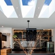 an open kitchen and dining room with skylights