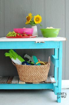 a blue table with baskets and flowers on it