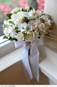 a bouquet of white flowers sitting on top of a window sill