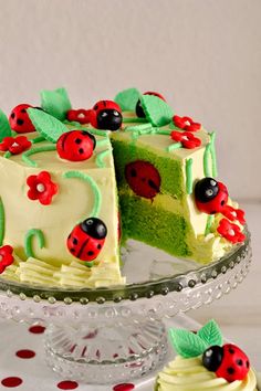 a cake with ladybugs on it sitting on top of a glass platter