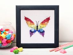 a colorful butterfly in a black frame next to some candy