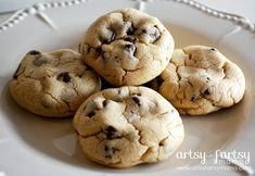 four chocolate chip cookies on a white plate