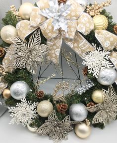 a christmas wreath with silver and gold ornaments