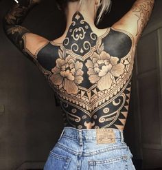 a woman with tattoos on her back and shoulder