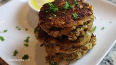 some food on a white plate with a lemon and parsley garnishes