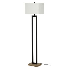 a floor lamp with a white shade on the top and a black metal base,