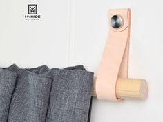 a pair of pants hanging on the side of a wall next to a wooden handle