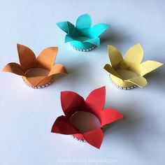 four paper flowers sitting on top of each other