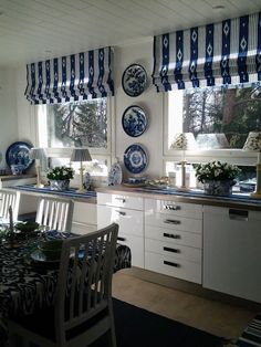 a kitchen with blue and white plates hanging on the wall next to a dining room table