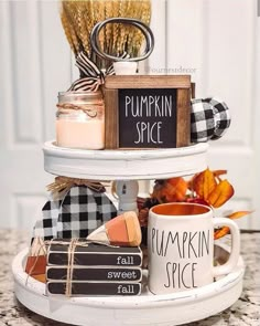 a three tiered tray holding coffee mugs and pumpkin spice, with the words pumpkin spice written on it