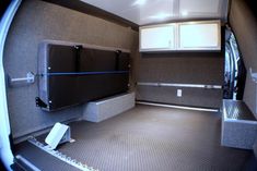 the inside of an rv with its door open and storage boxes on the floor in front of it