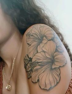 a woman's arm with a flower tattoo on it