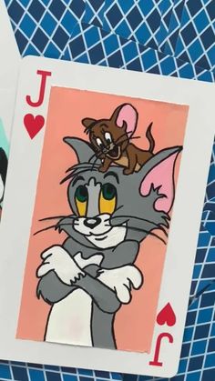 two playing cards, one with a cat and the other with a mouse on it