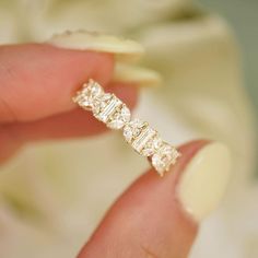 a woman's hand holding a diamond ring