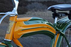 an orange and green bike parked on the side of a road