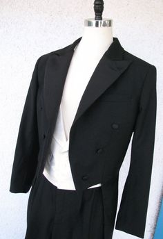 ABOUT THIS STYLE: A classic white tie suit straight out of the 1930s. This look features a formal tailcoat with silk-face grosgrain peak lapels, a pointed hemline, and curved tails. The outfit also features a white silk peak lapel vest and a custom formal pleated pant with a high waist. This style is famous for elongating the legs and creating the ultimate look of formal elegance. CUSTOM MADE: You can choose all of the details (tail shape, lapel shape, pant and cuff style) and fabrics (wools and Classic Fitted Three-piece Suit For Black Tie Event, Fitted Classic Three-piece Suit For Black Tie Event, Classic Black Tie Three-piece Suit, Classic Three-piece Suit For Black-tie Events, Classic Single-breasted Tuxedo For Black Tie, Classic Fitted Single Breasted Tuxedo, Classic Single Breasted Fitted Tuxedo, Classic Single-breasted Fitted Tuxedo, Classic Fitted Single-breasted Tuxedo