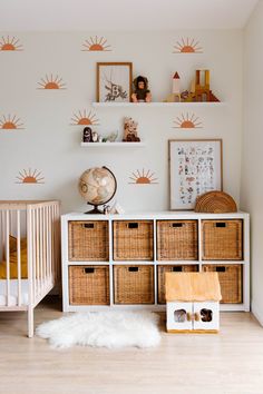 a baby's room with sun decals on the wall and toys in baskets