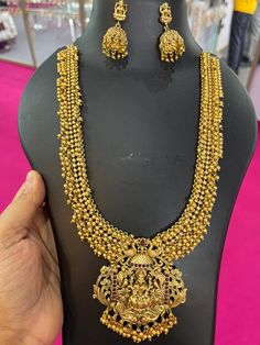 south Antique Gold Temple jewelry set statement Necklace Lakshmi Jewelry set Gold wedding Necklace Set Indian long Necklace South Jewelry This handmade designer crescent design 4 step statement antique gold plated is studded with lakshmi motifs, kemp stones and white pearls. This south indian jewelry can be worn for wedding and festive occasions paired with traditional outfits like saree and lehenga. Temple Jewelry enhances the look of the sarees, ghagra cholis, and Salwar kameez. If you love th Luxury Gold Temple Necklace For Festive Occasion, Luxury 22k Gold Traditional Temple Necklace, Luxury Heavy Gold Temple Necklace, Luxury Gold Temple Necklace Gift, Luxury Yellow Gold Chandbali Temple Necklace, Traditional Brass Temple Necklace, Luxury, Luxury Brass Temple Necklace For Festive Season, Lakshmi Gold Necklace, Luxury Antique Temple Necklace For Ceremonies