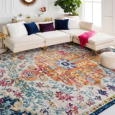 a living room with white couches, colorful rug and large mirror on the wall