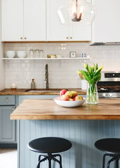 a bowl of fruit sits on the kitchen island