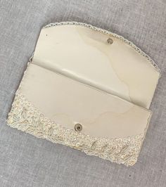 "Beautiful vintage clutch Adorned with a ivory white sequins and beading. Satin self & lining 50s 60s glamour. ~ good vintage condition ~ snap closure ~sequins ~beading ~satin lining ~one main compartment ~one small pocket compartment Measurements Length: 8\" Height: 4\" Condition: Great Some water staining to inside and back see photos Brand: N/A Made in Hong Kong Material: satin, sequins, beading, snap ❉ All items are vintage and have been worn and loved, some small flaws may go unnoticed. Vintage Beige Clutch For Party, Vintage Beige Clutch For Wedding, Vintage Beige Evening Bag For Events, Vintage Beige Wedding Clutch, Vintage White Beaded Clutch, Vintage White Clutch Evening Bag, Vintage Cream Rectangular Clutch, Embroidered Cream Clutch For Evening, Vintage White Clutch For Party